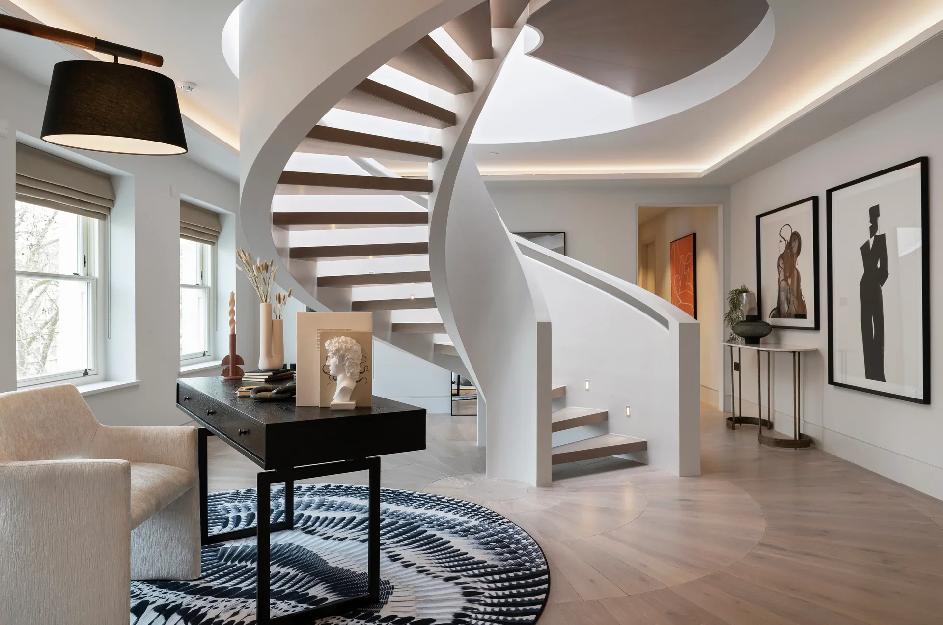 Modern interior featuring a sculptural white spiral staircase with wooden treads and soft ambient lighting.