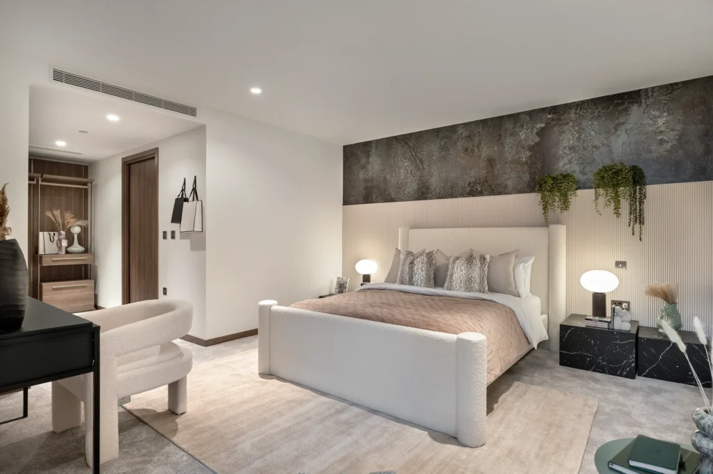 Modern bedroom featuring a large bed, minimalist decor, and a stylish combination of lighting and plants.