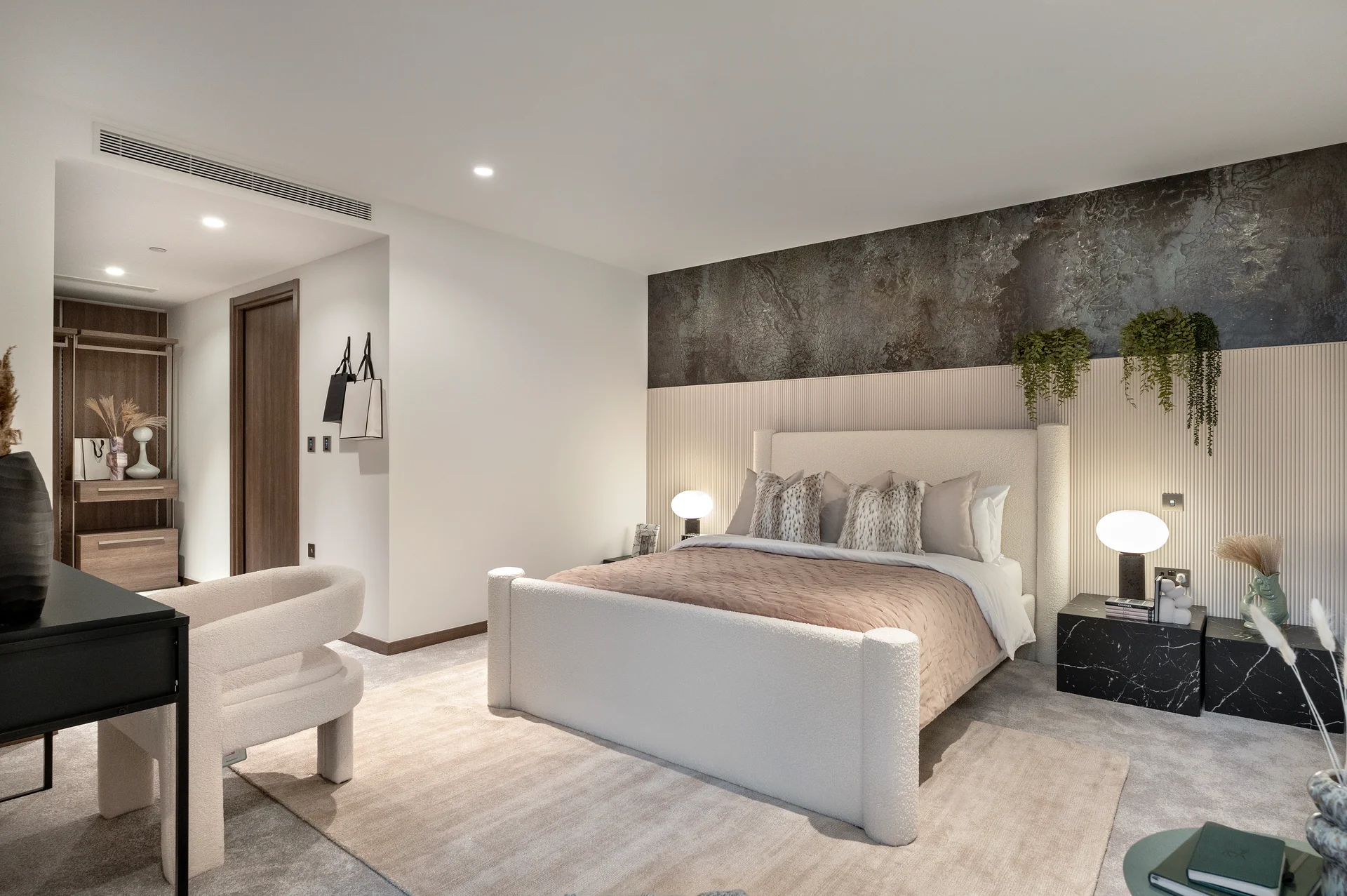 Modern bedroom featuring a large bed, minimalist decor, and a stylish combination of lighting and plants.