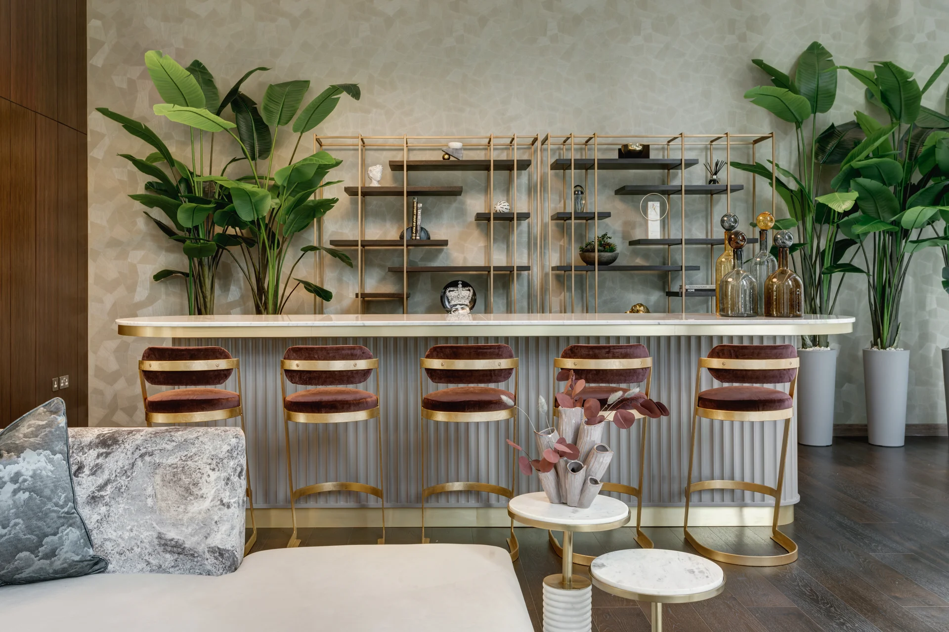 Modern reception area featuring a stylish bar, plush seating, and decorative plants.