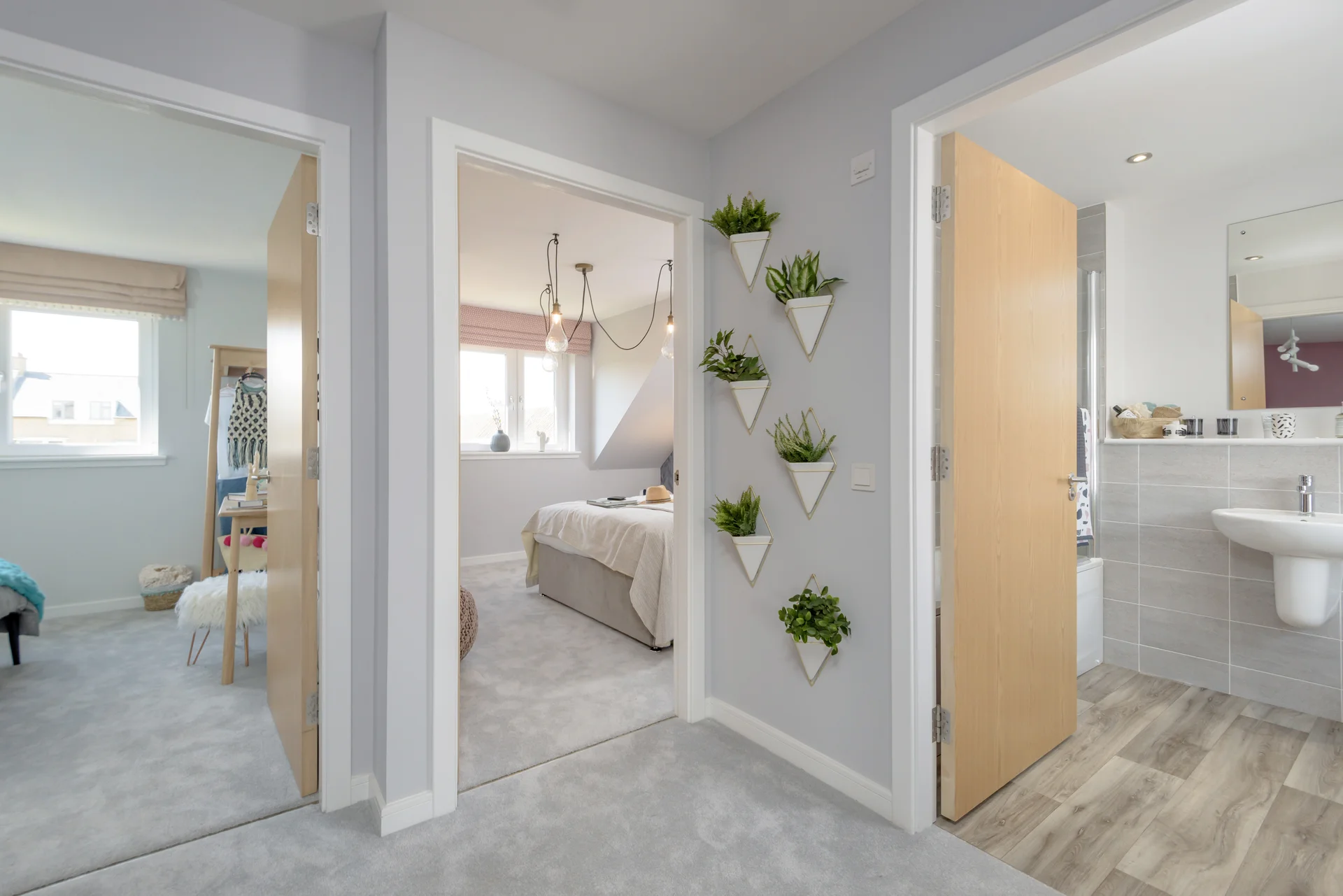 View of a hallway with two doorways, featuring a wall of triangular plant holders and access to a bathroom.