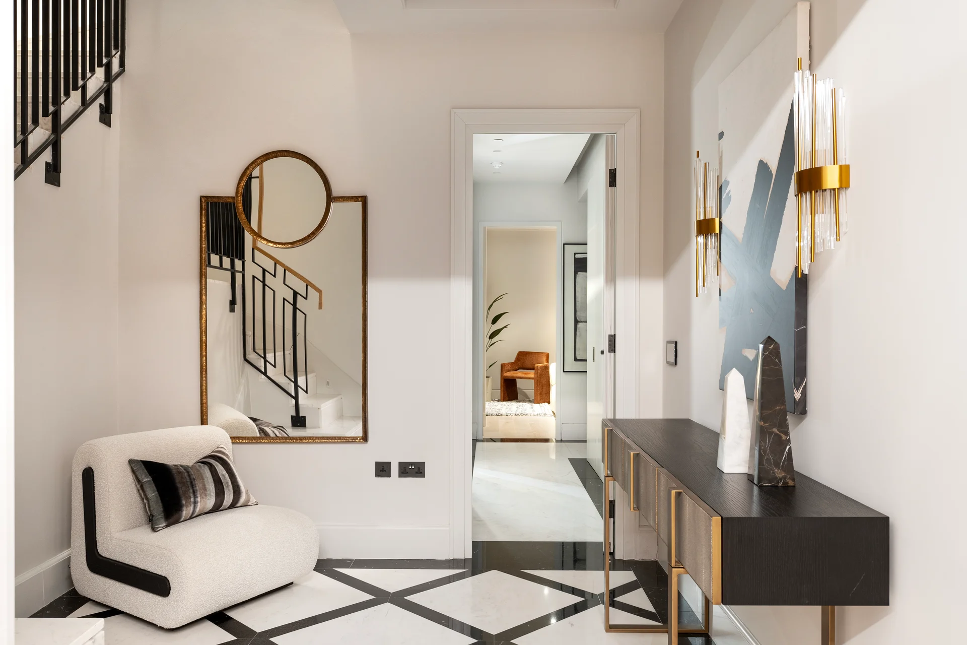 Modern hallway featuring a stylish sofa, decorative mirror, sleek console table, and elegant lighting fixtures.