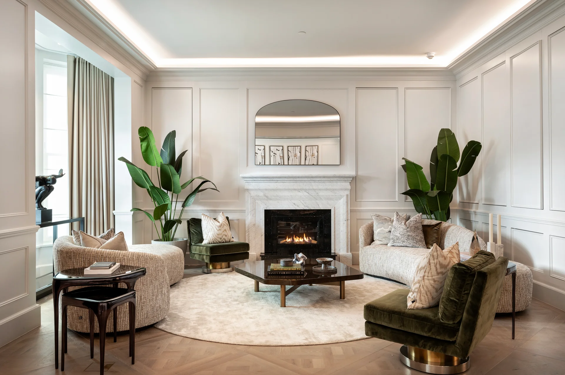 Modern living room featuring a cozy fireplace, lush plants, and stylish furniture against a light-colored wall.