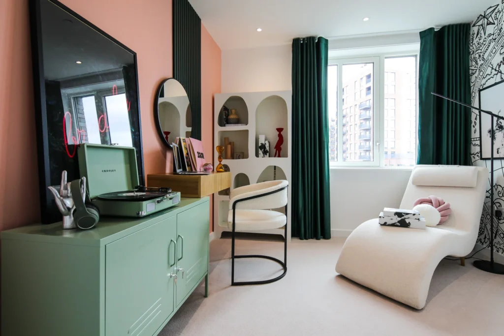 Stylish interior featuring a green cabinet, a white chaise lounge, and large windows with green curtains.