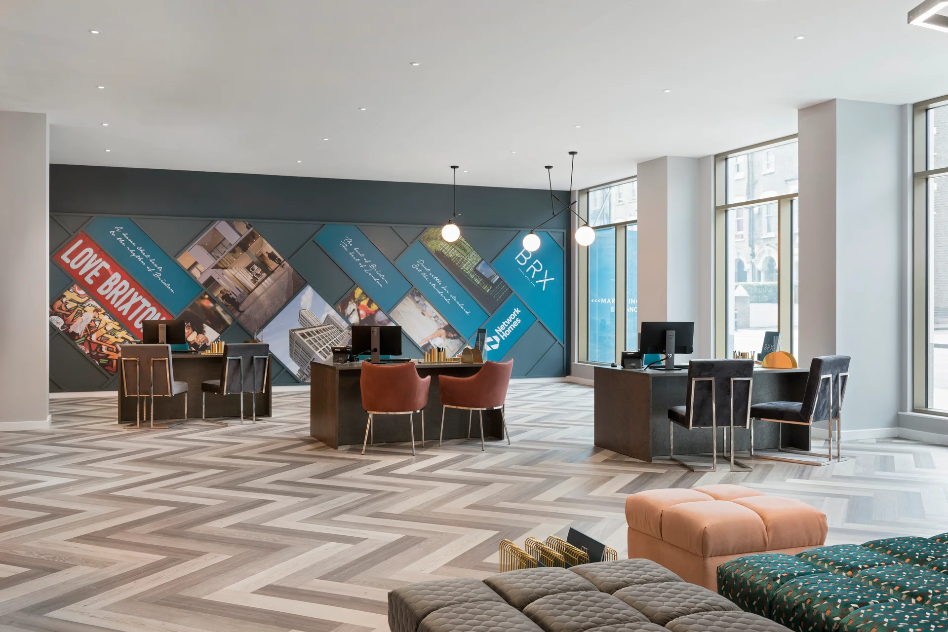 Modern open space with workstations, chairs, and a wall featuring promotional graphics in a contemporary design.