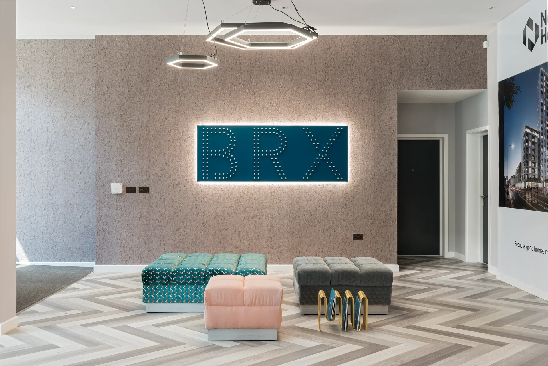 Modern lobby with patterned flooring, colorful benches, and a lit "BRX" sign on the wall.