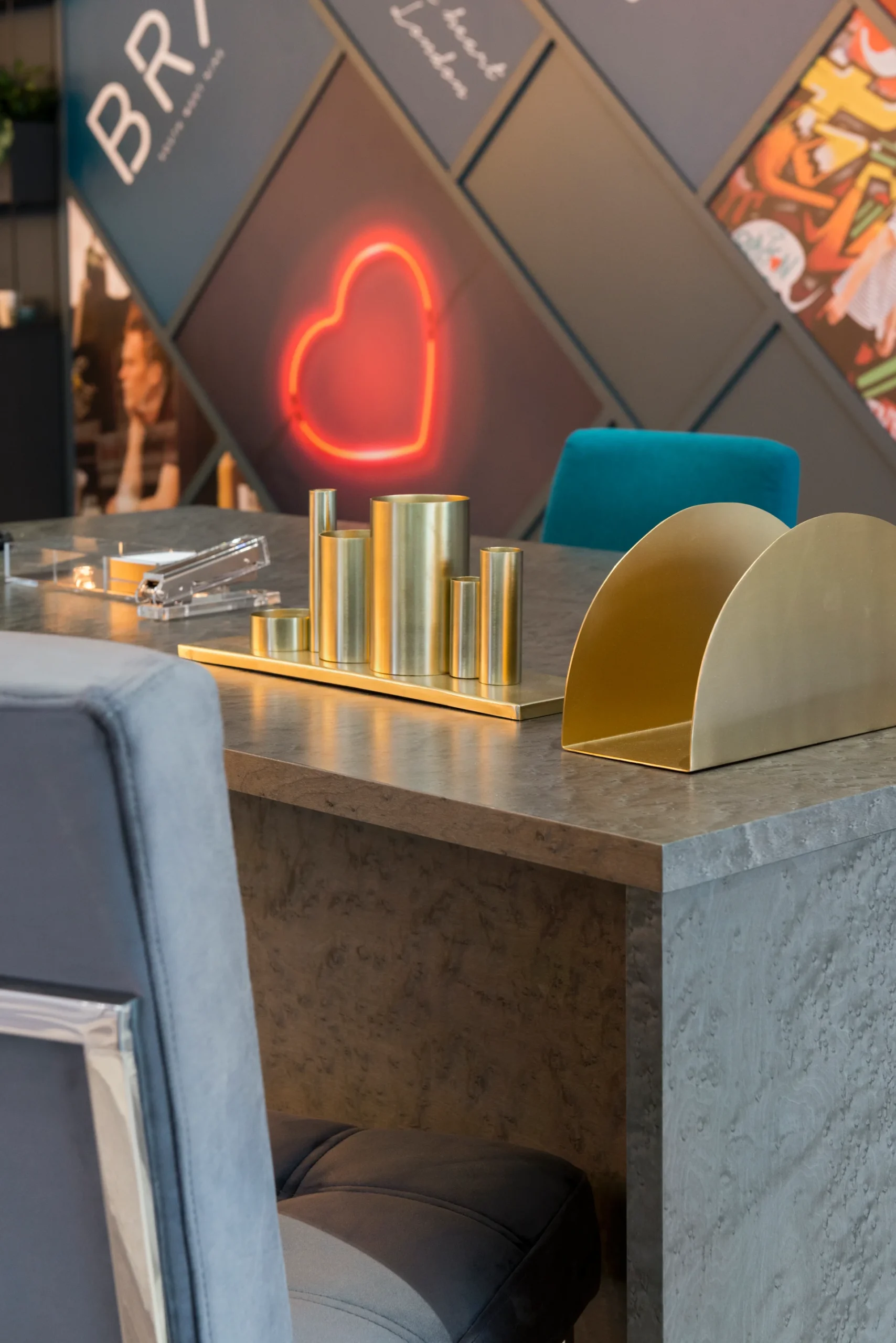 A modern decor setup featuring a stylish table, decorative items, and a neon heart-shaped light in the background.
