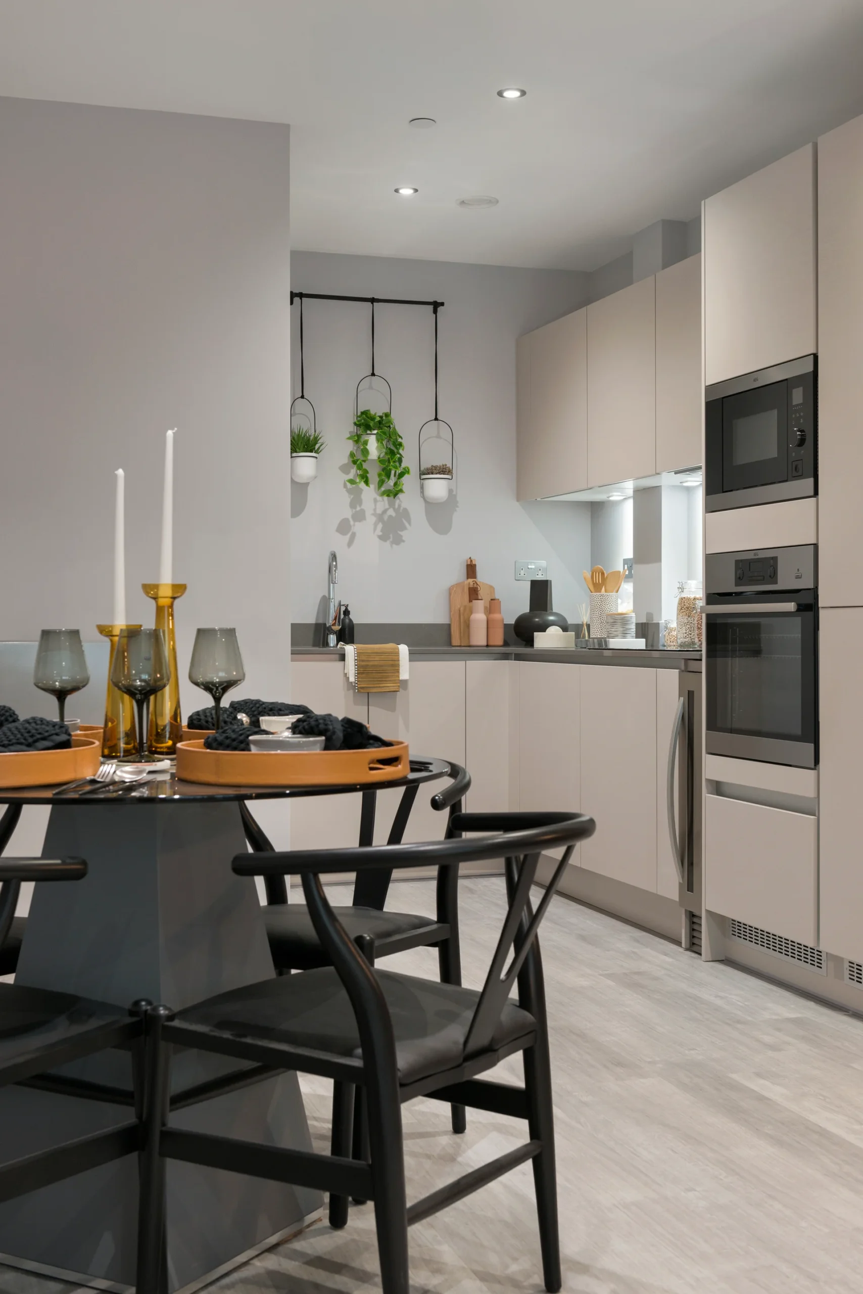 Stylish kitchen with gray cabinets, modern appliances, and a dining table set for two.