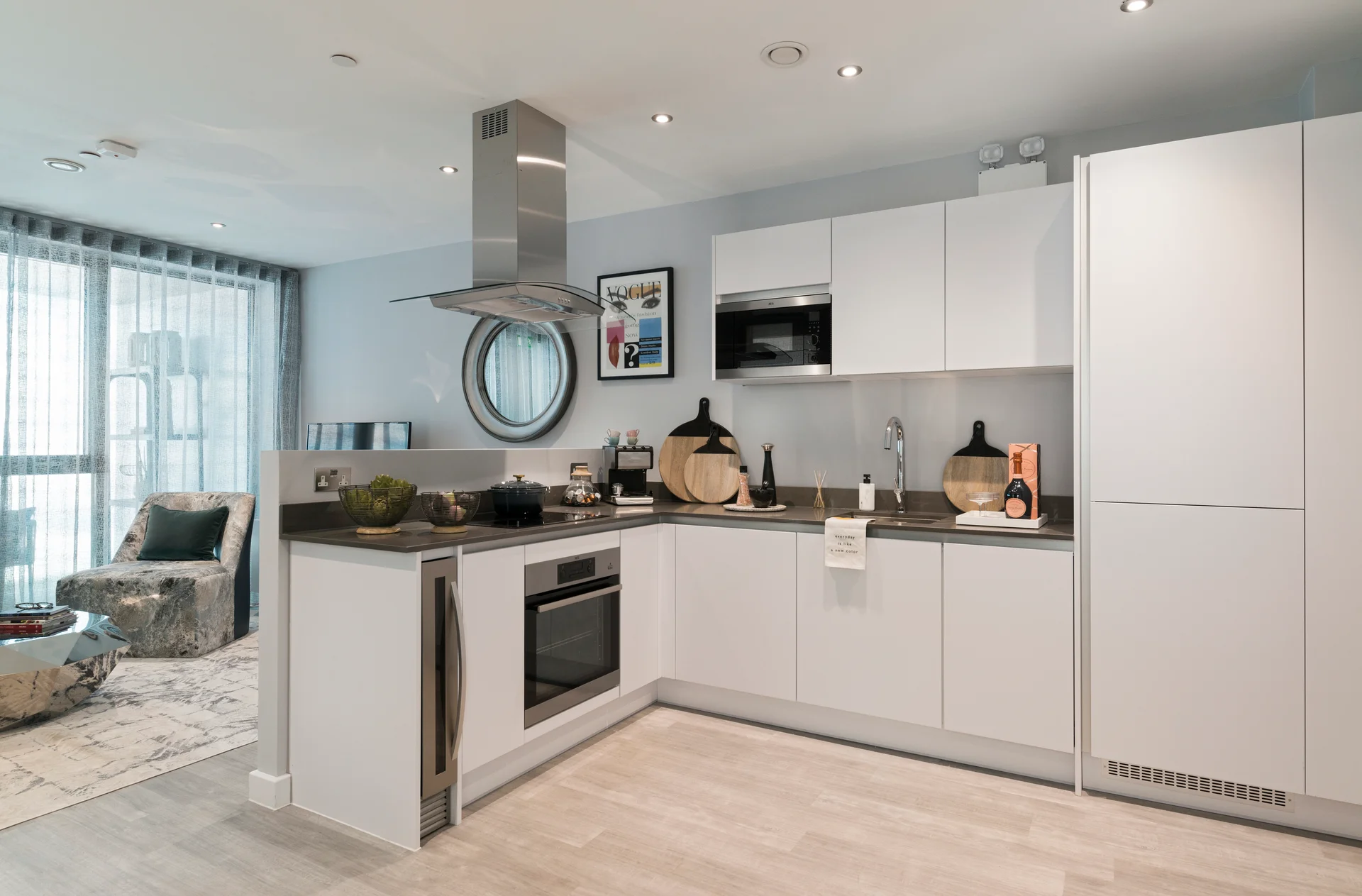 Modern kitchen with white cabinetry, stainless steel appliances, and an island, featuring a cozy dining area nearby.