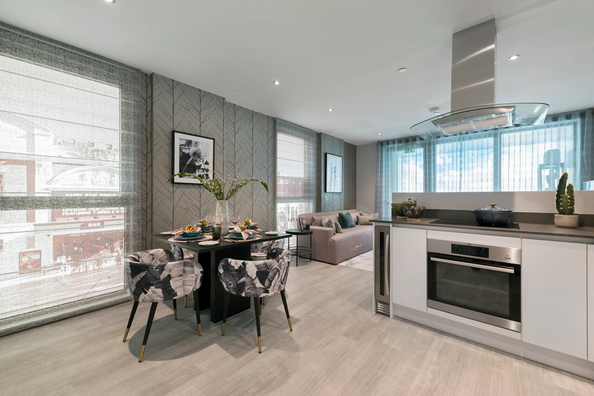Modern kitchen and dining area with stylish decor, featuring a table set for a meal and a cozy sofa in the background.