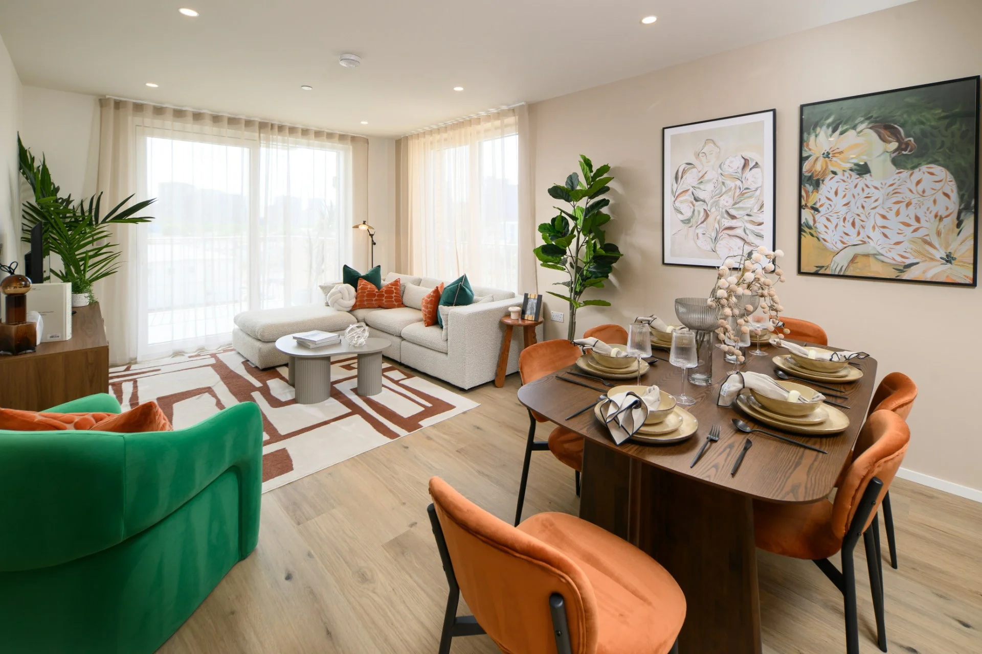 Modern living room and dining area featuring a green chair, orange dining chairs, and decorative plants.